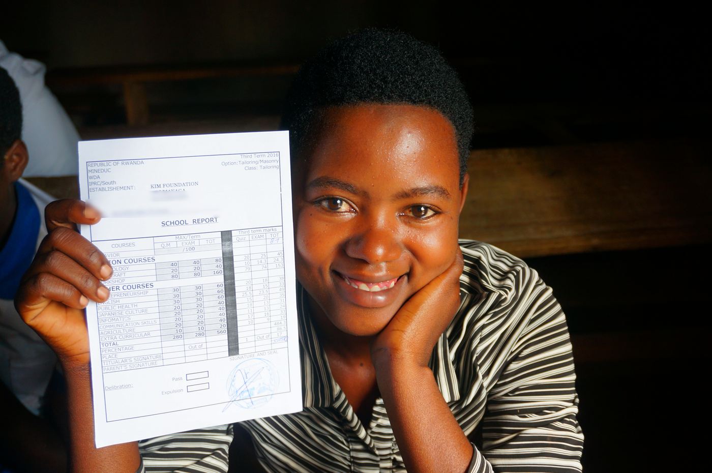 A student smiling with her school report